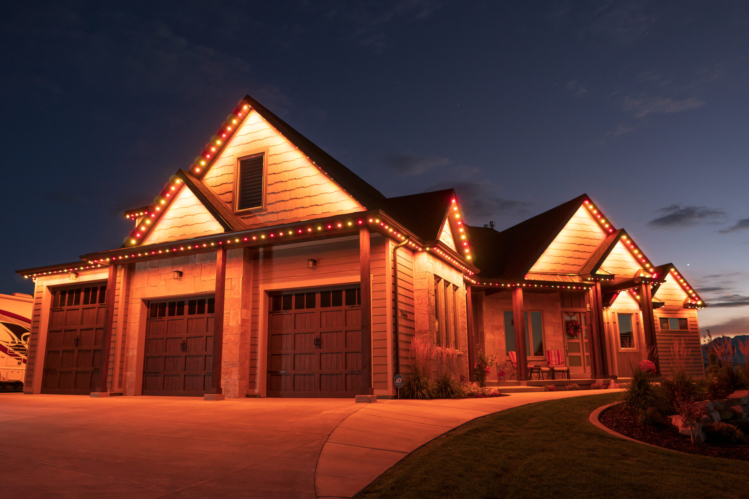 Modern house with orange permanent LED lighting accenting the roofline at night